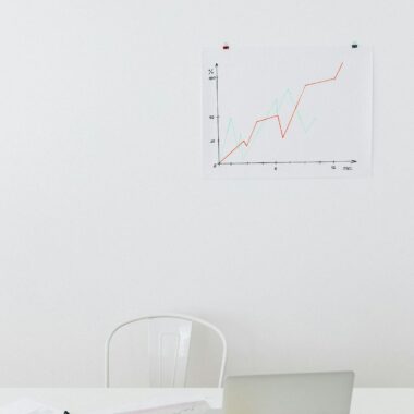 Clean desk setup with chart, laptop, and office supplies for analysis.